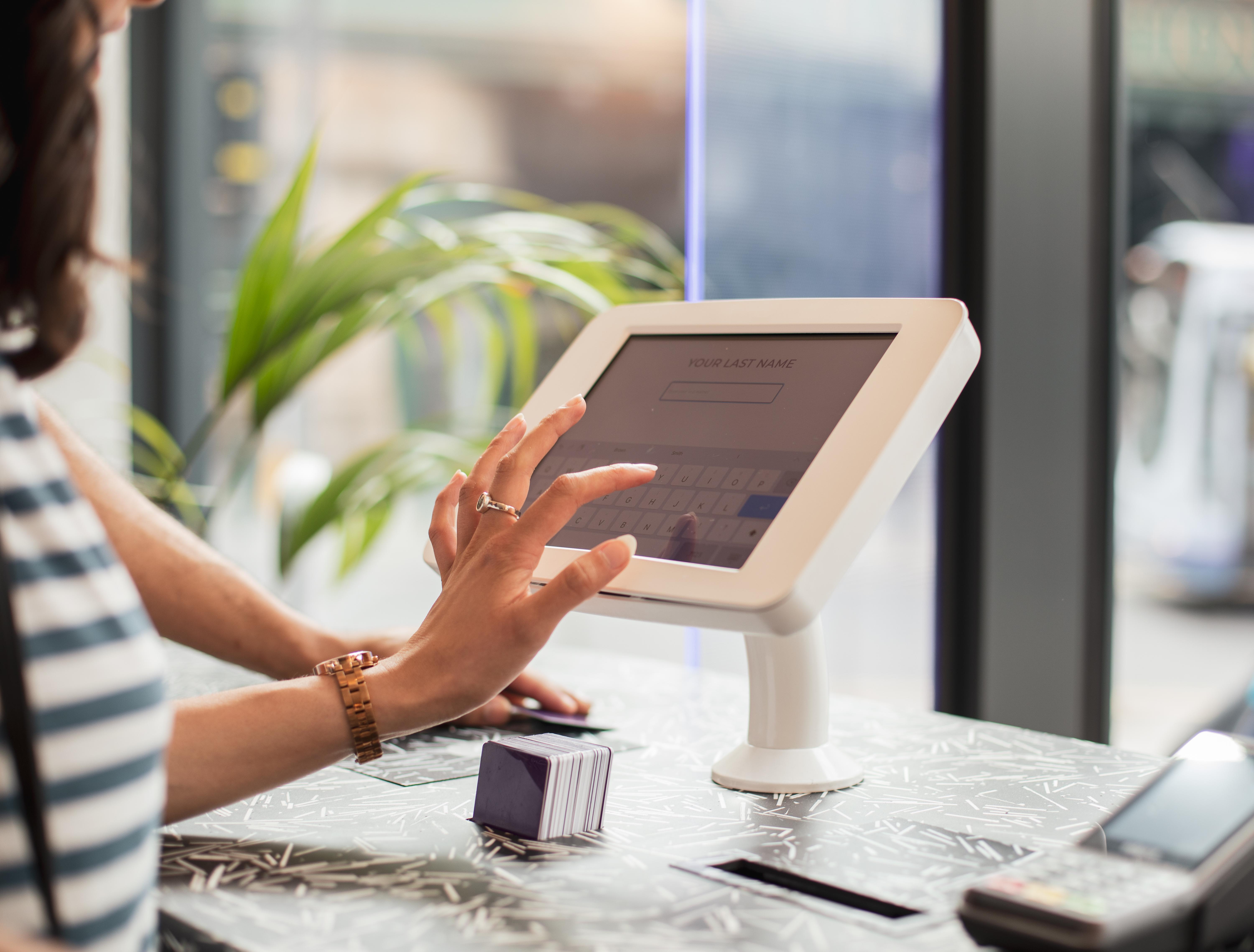 Yotel غلاسغو المظهر الخارجي الصورة A woman using a tablet to enter her name at a check-in desk