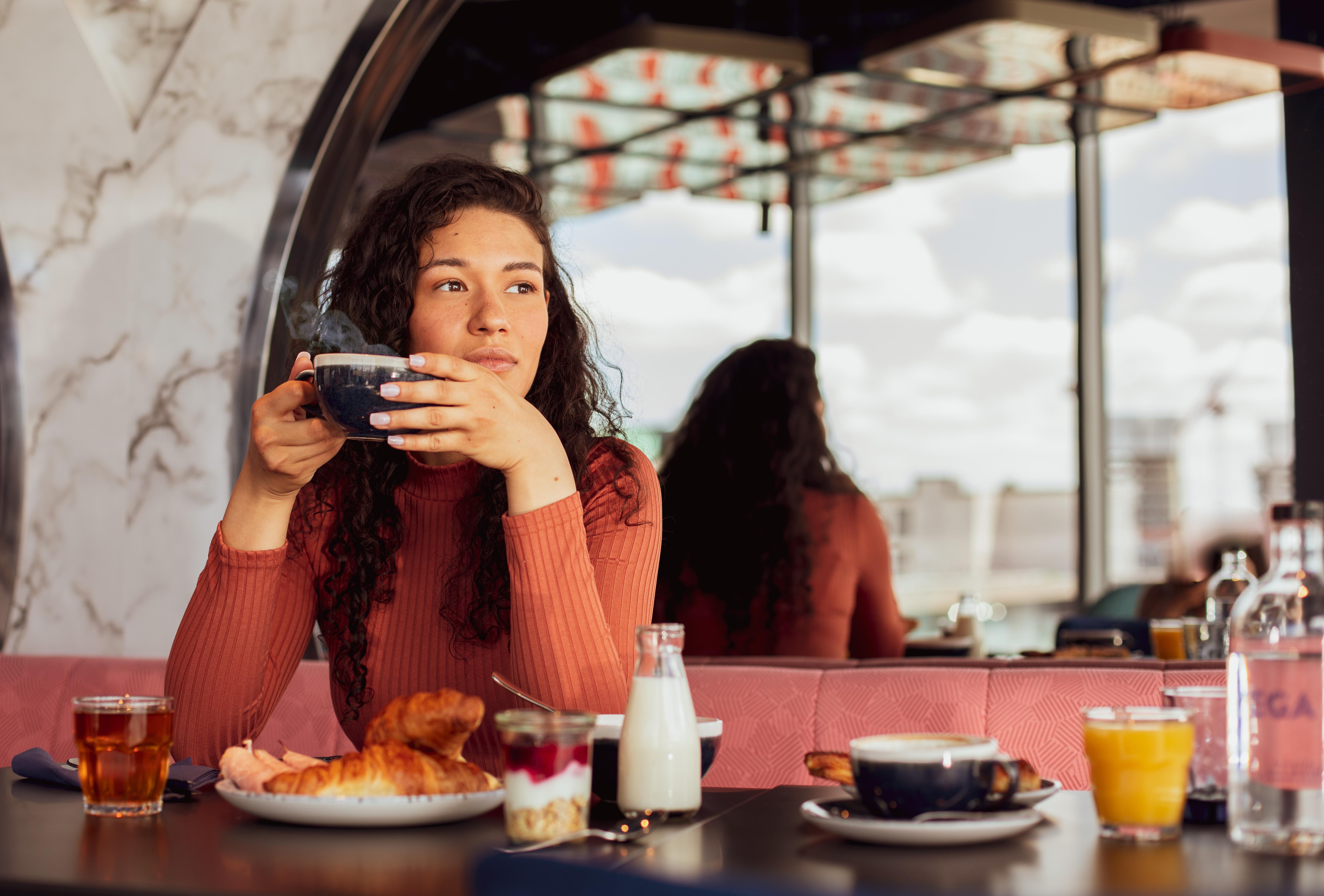 Yotel غلاسغو المظهر الخارجي الصورة A woman having breakfast at a cafe.