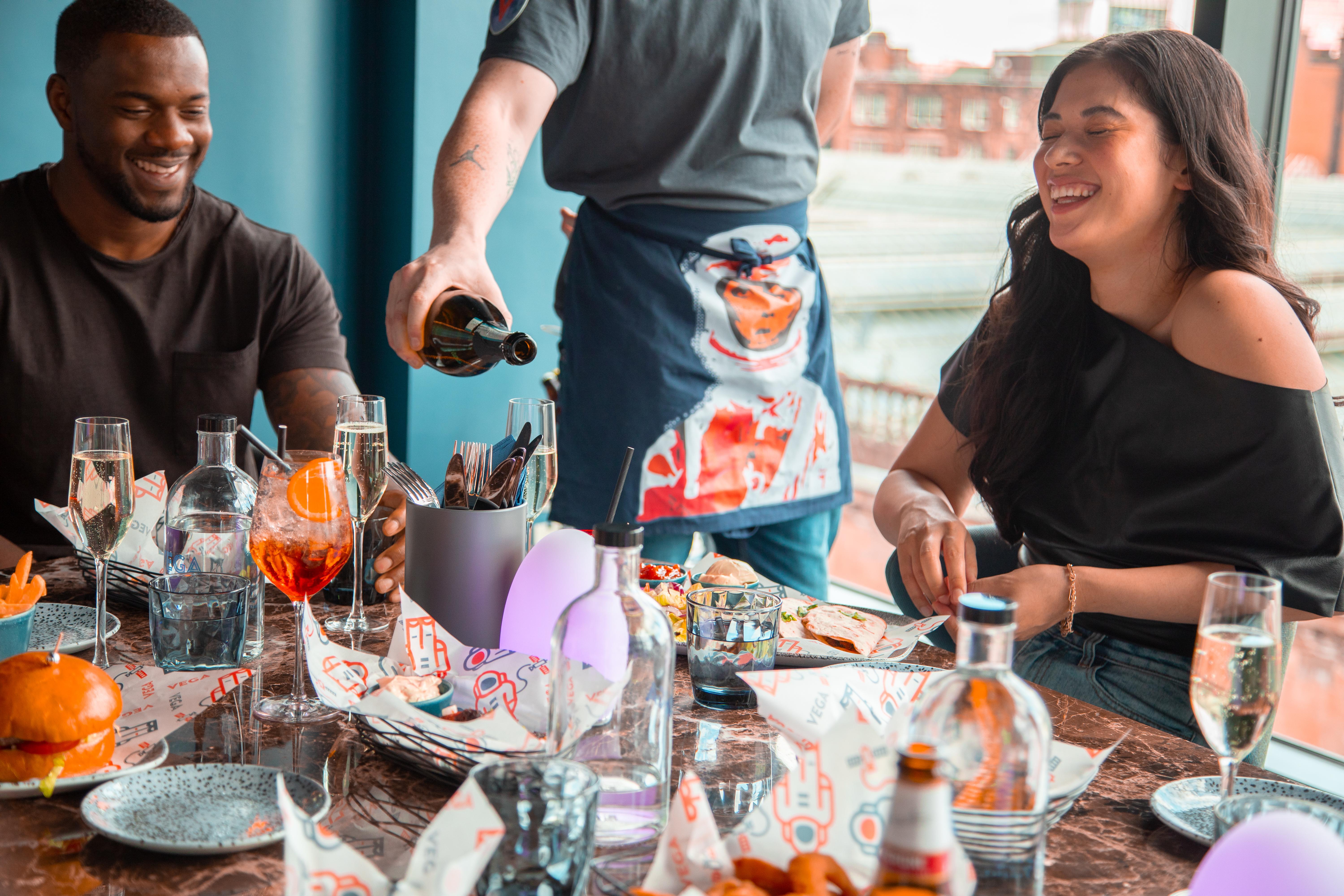 Yotel غلاسغو المظهر الخارجي الصورة A waiter serving a couple drinks at a restaurant